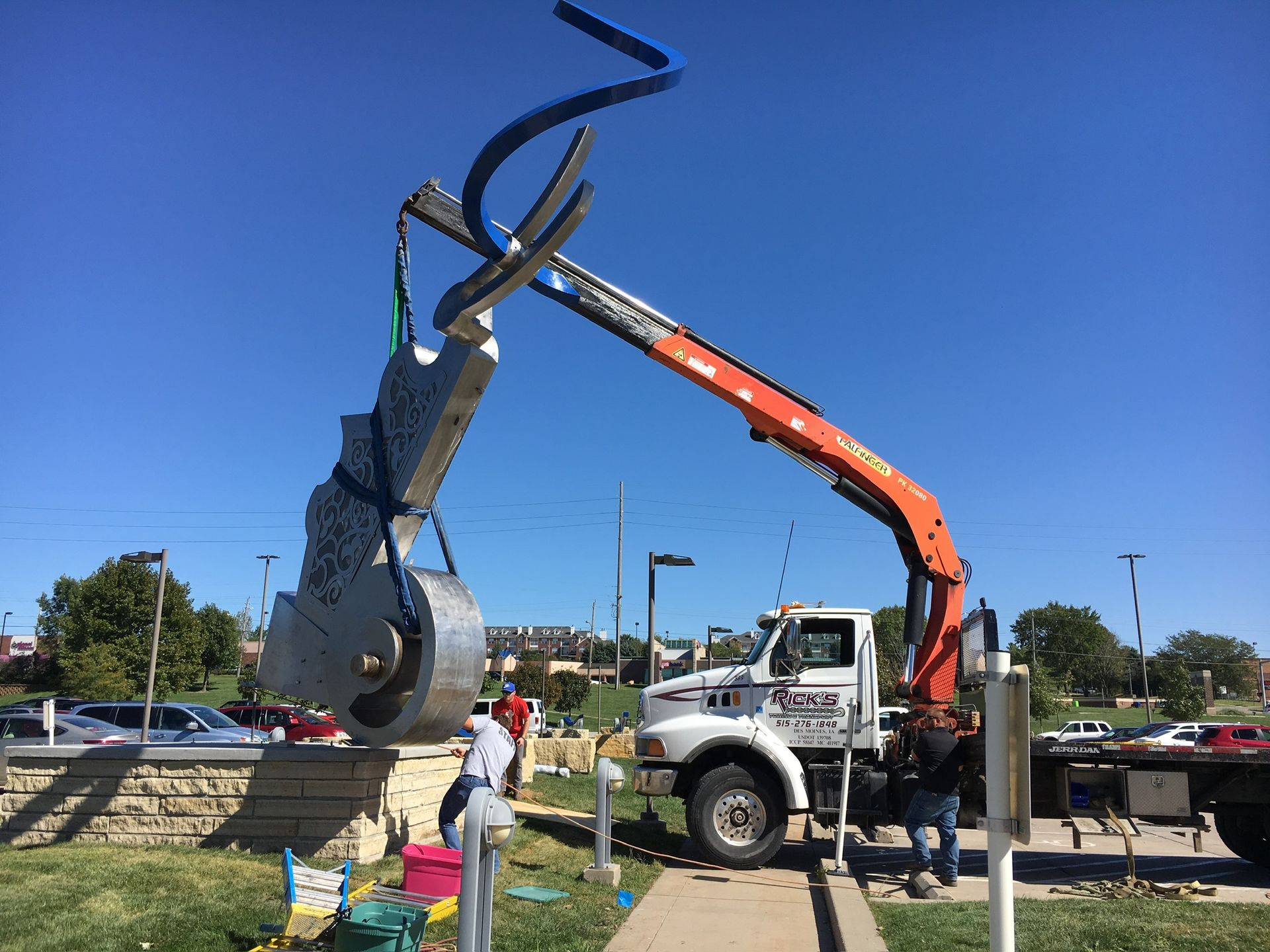 A large sculpture is being lifted by a crane.