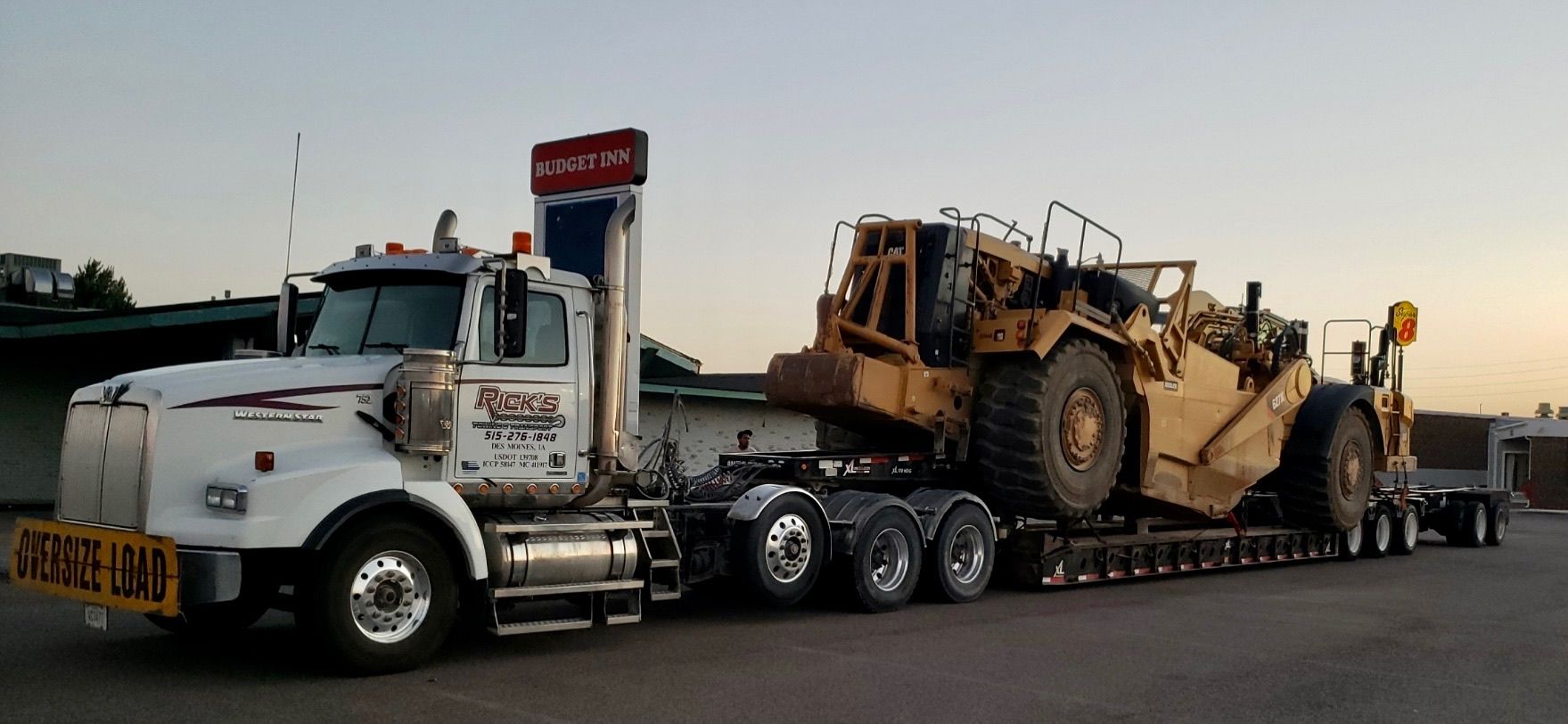 A semi truck is carrying a bulldozer on a trailer.