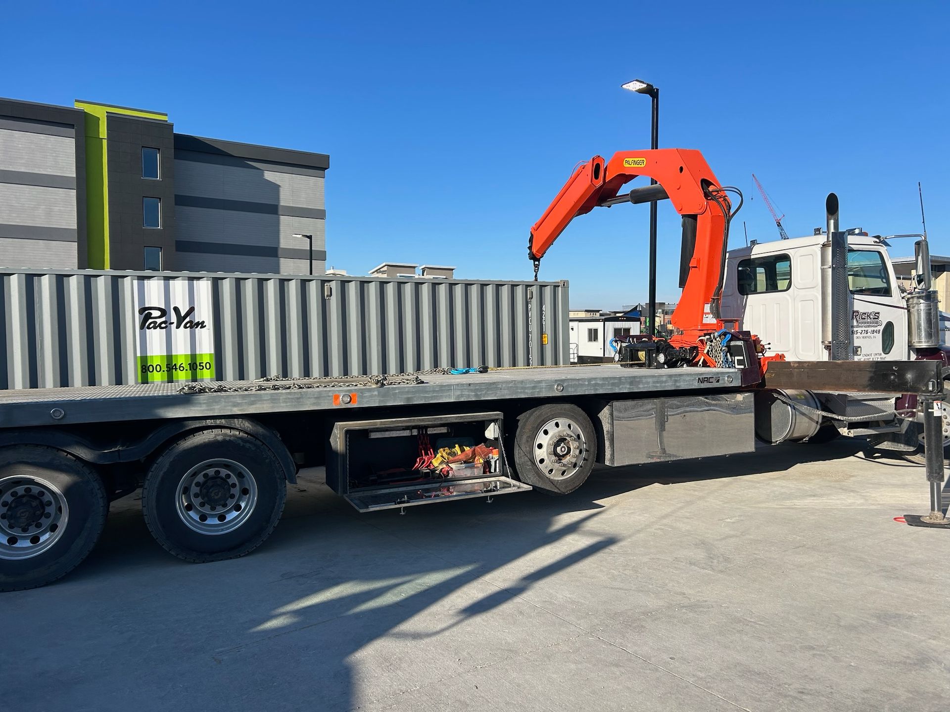 A flatbed truck with a crane attached to it