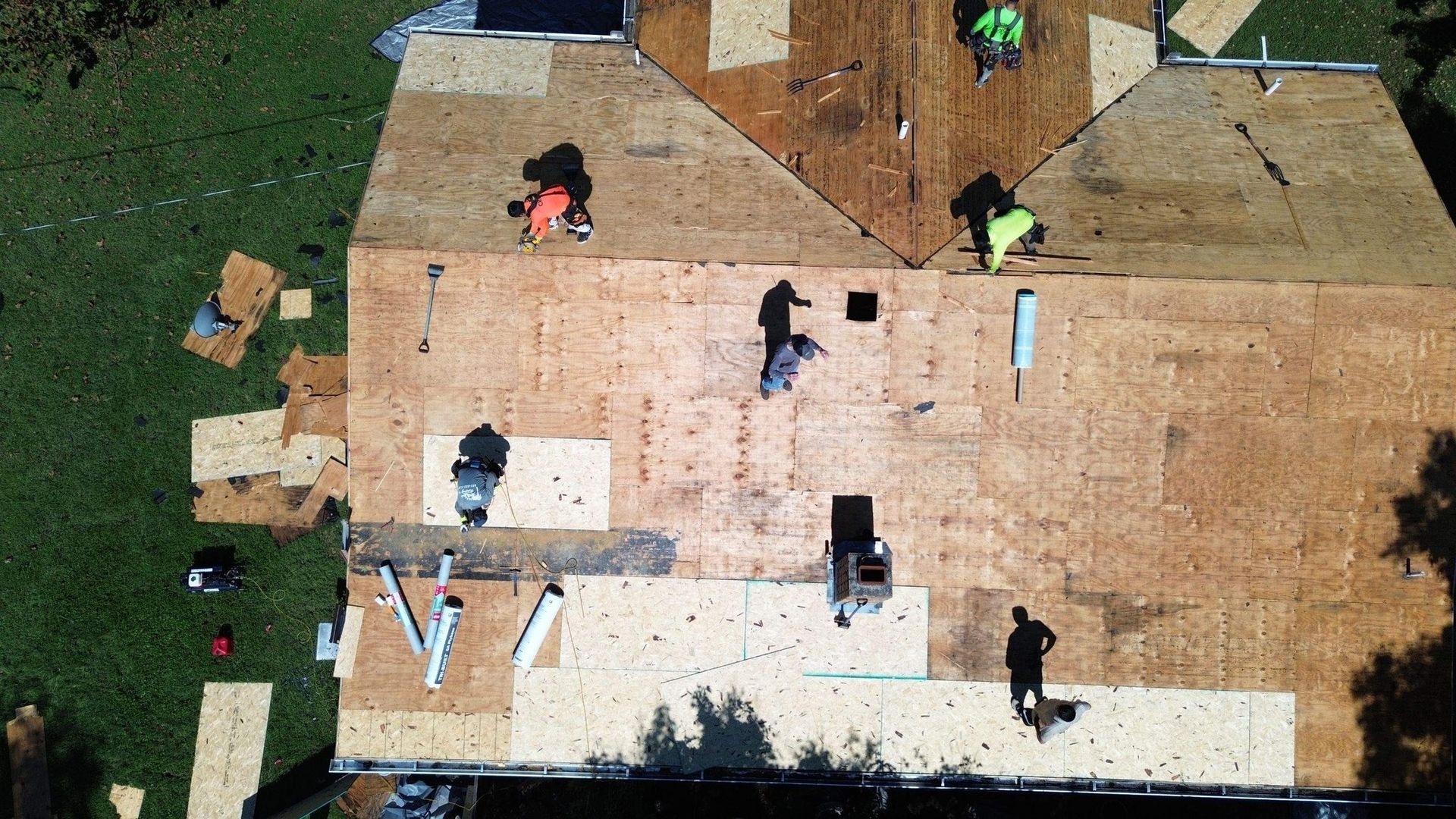 Roofers working on a roof, removing old materials and preparing for new installation.