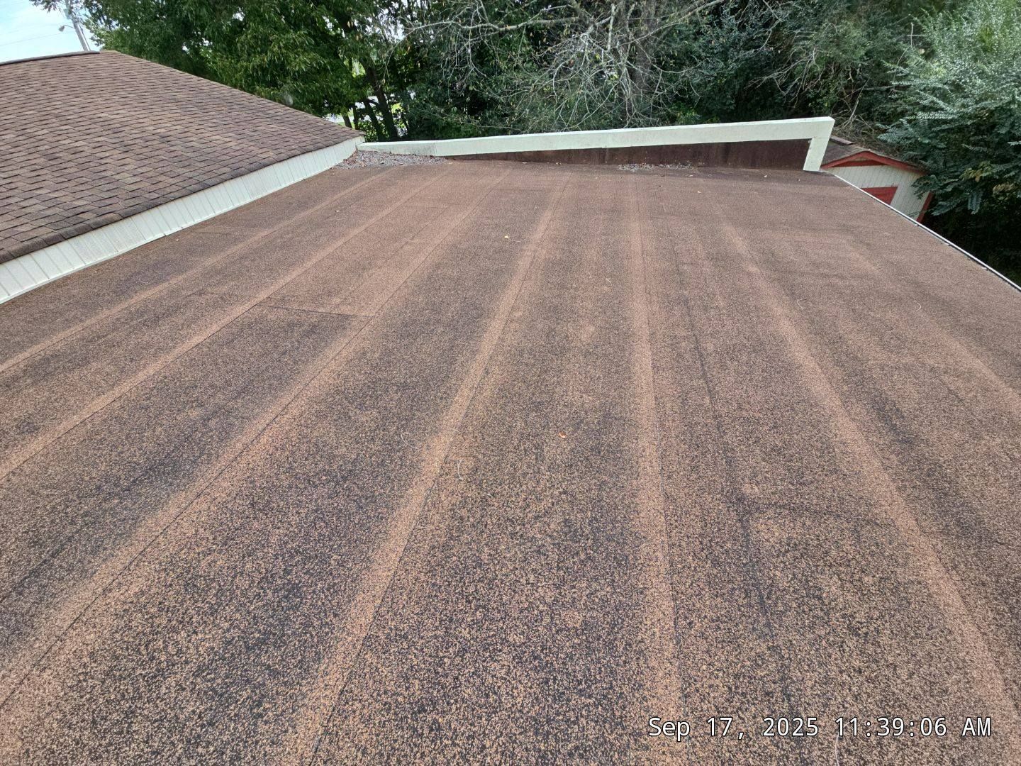 Brown shingle roof, close-up view. The roof has vertical lines and a white trim.
