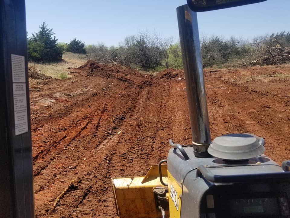 A bulldozer is driving down a dirt road.