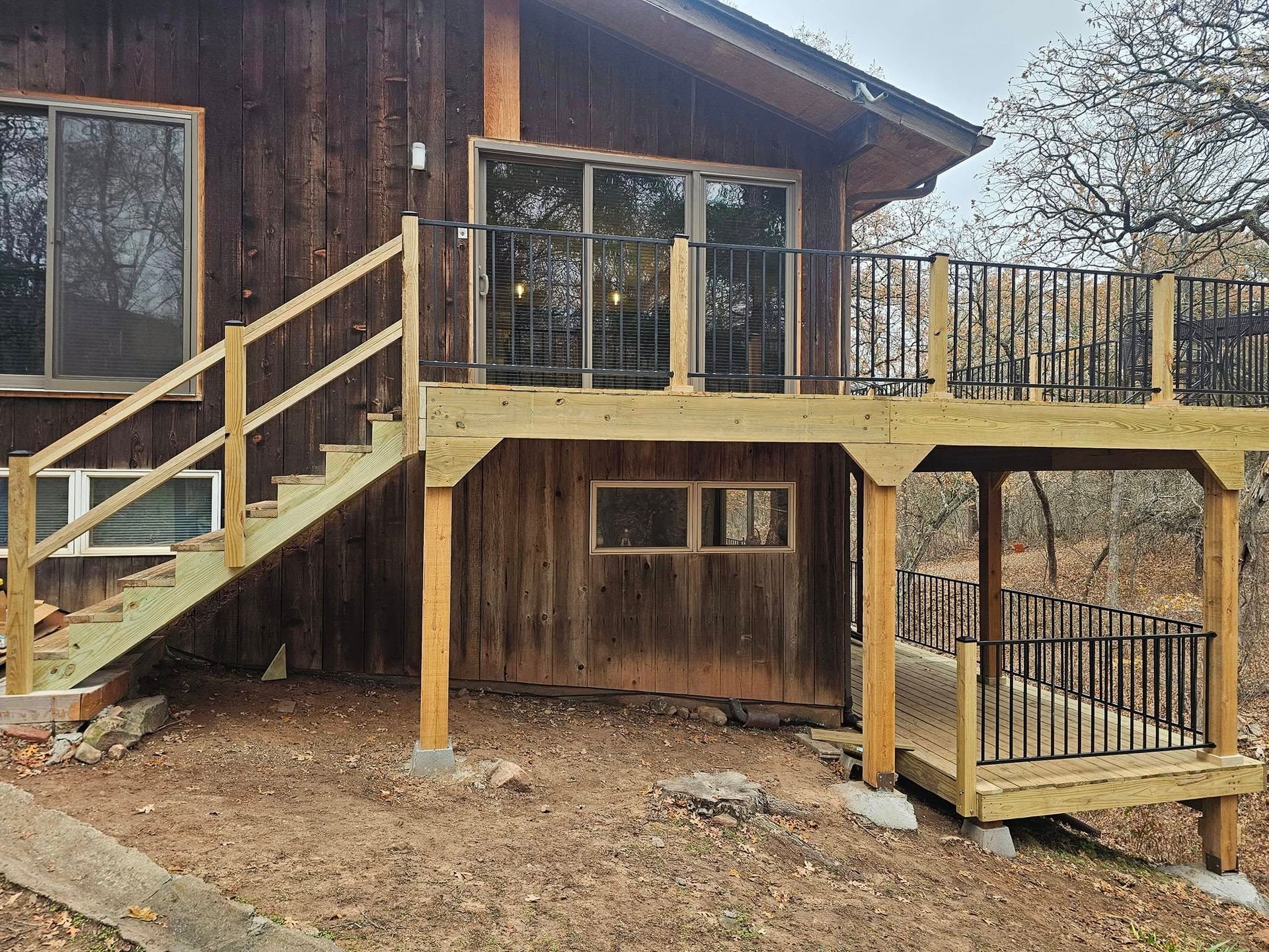 A wooden house with a wooden deck and stairs.