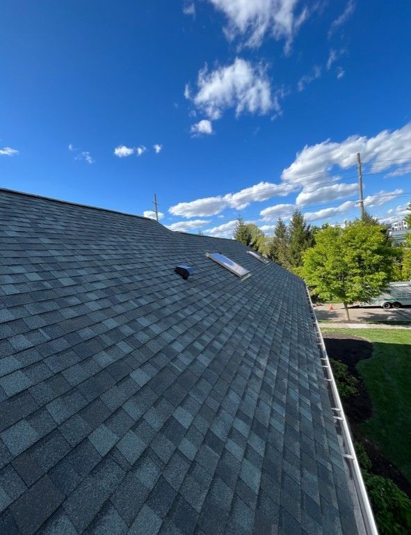 A roof with a skylight on it and a blue sky in the background.