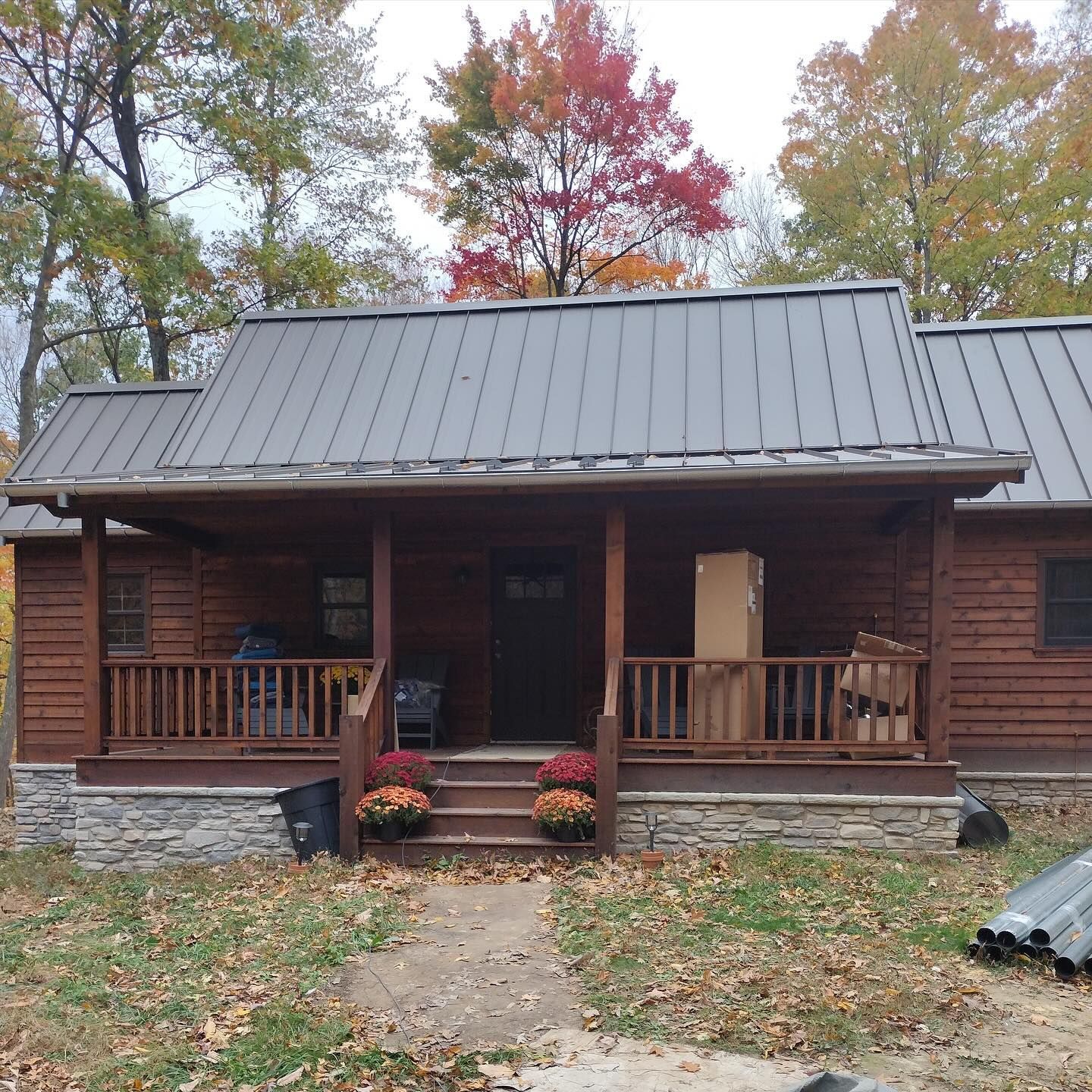 A small house with a metal roof and a porch
