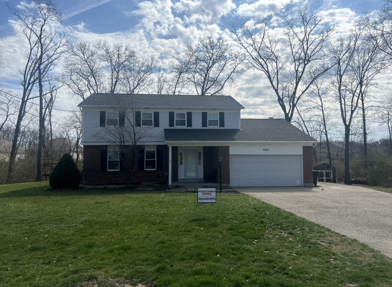 A large brick house with a white garage door is for sale.