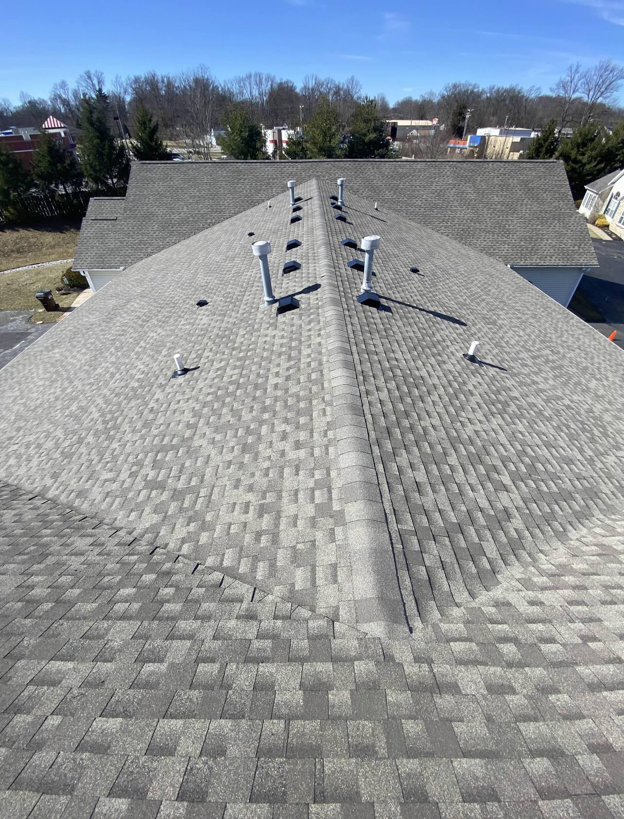 A roof with a lot of shingles on it and a lot of vents on it.