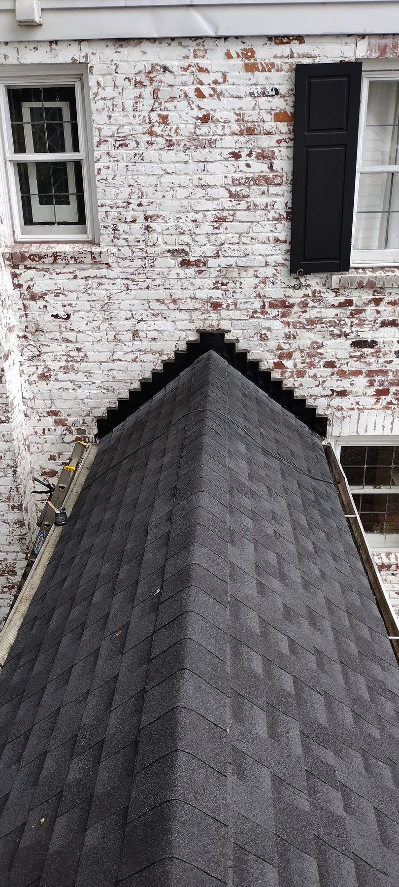 A white brick house with a black roof