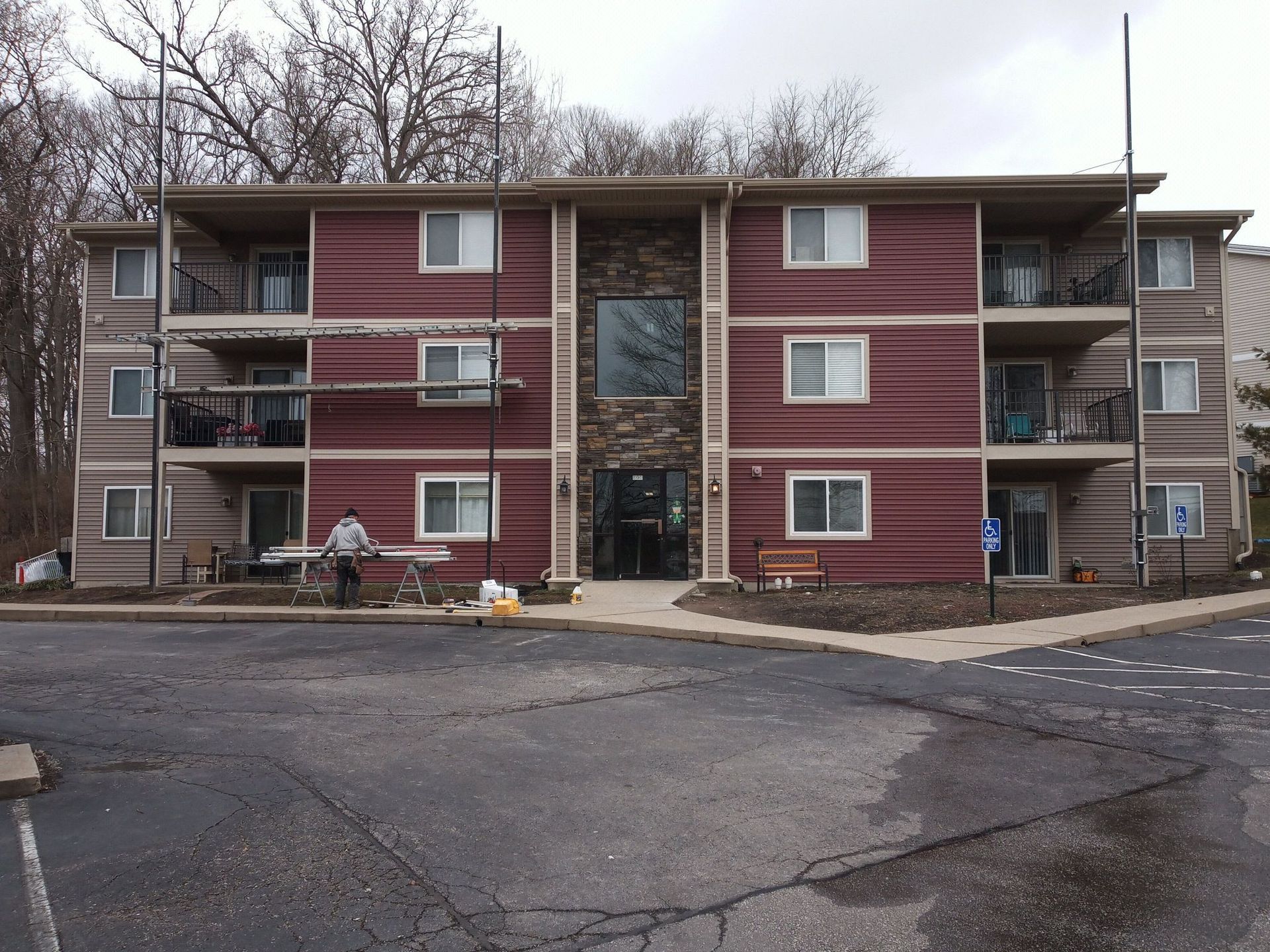 A large red apartment building with a parking lot in front of it