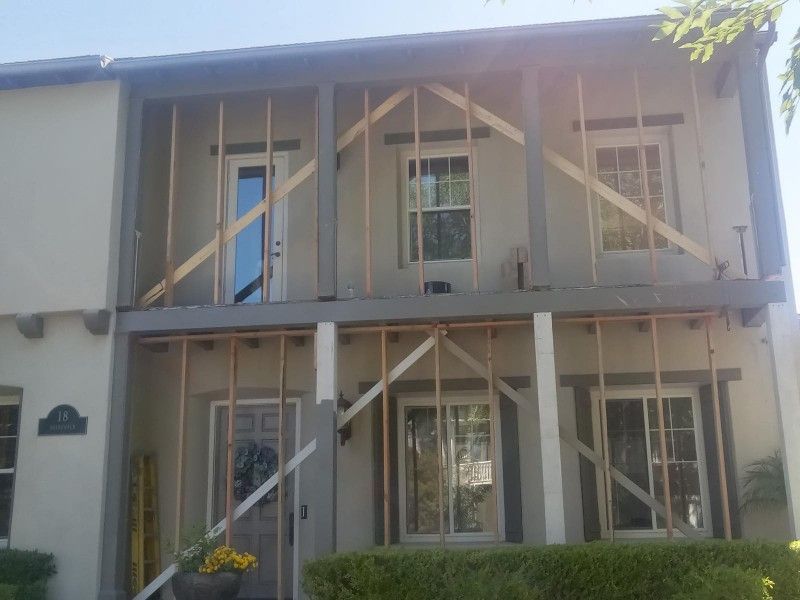 The front of a house is being remodeled with wooden beams.