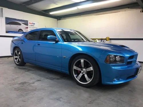 Blue sports sedan parked in a garage, shown from the front-left side.