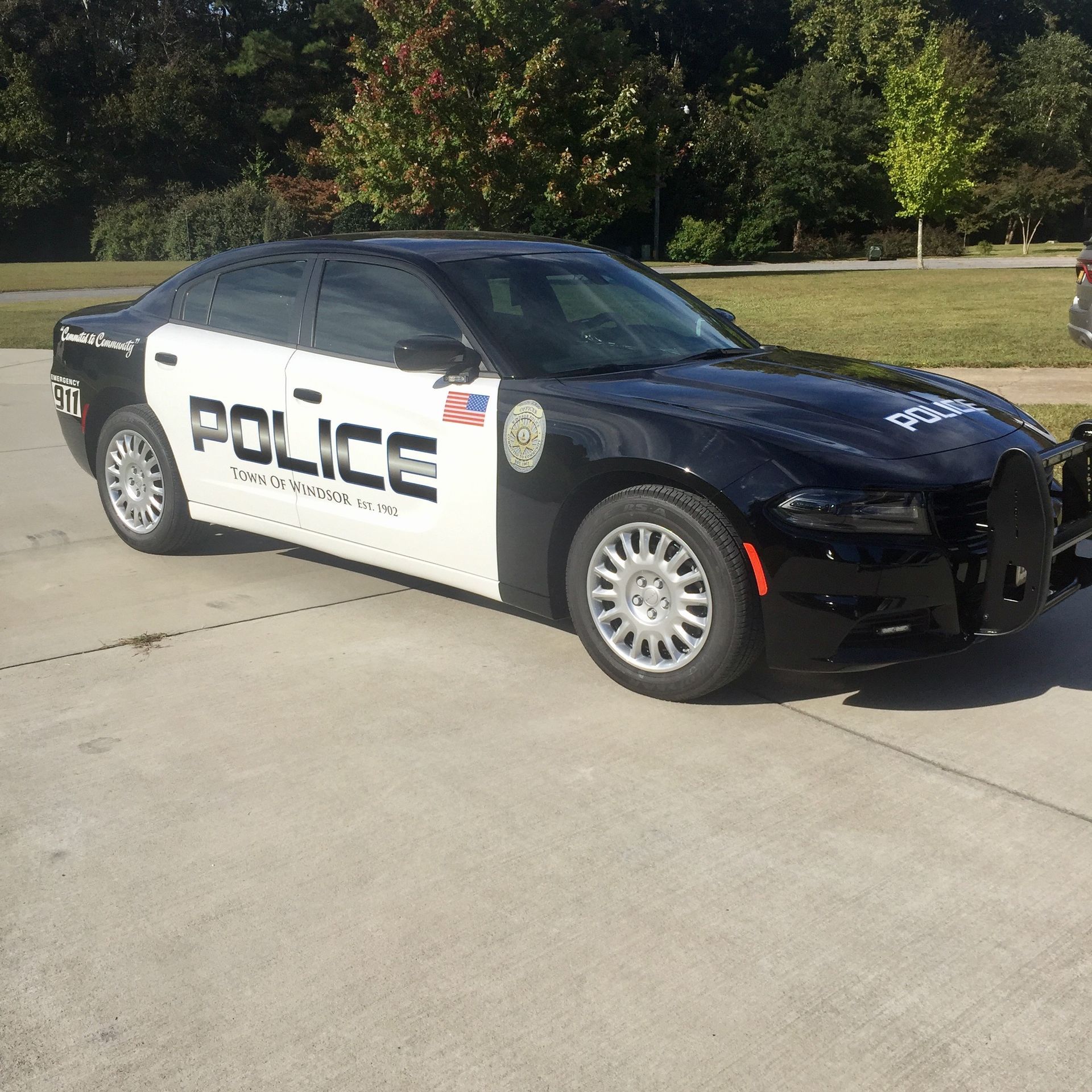 Black-and-white police car parked on a sunny street, side view