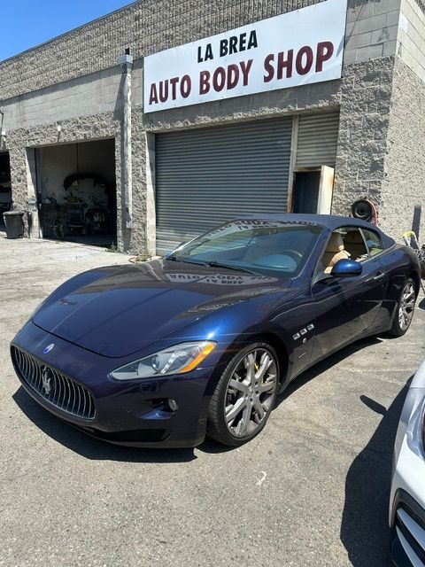 Blue luxury coupe parked outside La Brea Auto Body Shop