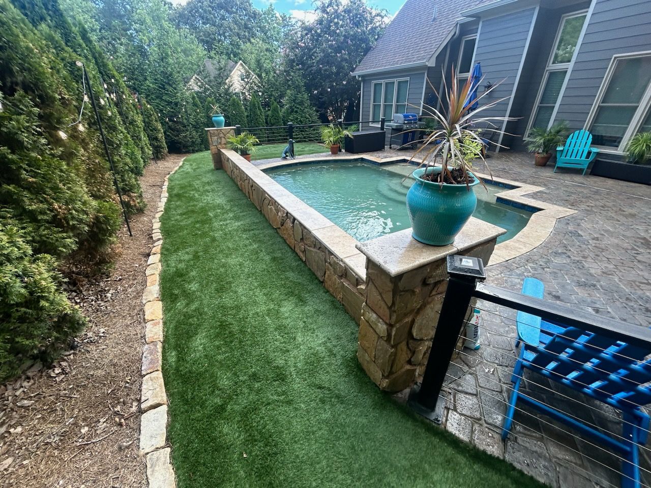 There is a large swimming pool in the backyard of a house.
