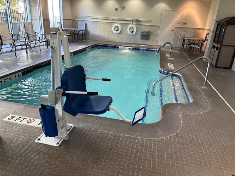 An indoor swimming pool with a wheelchair lift.