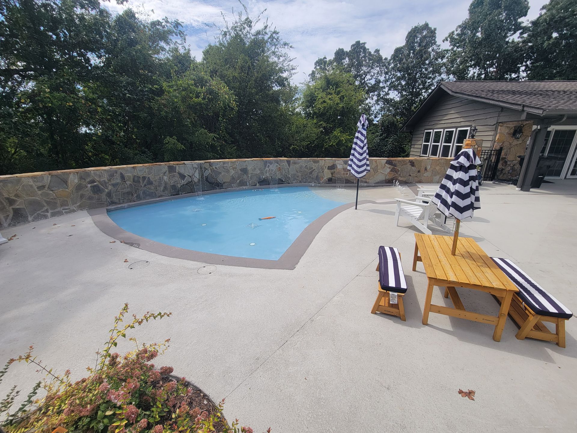 A large swimming pool is surrounded by chairs and umbrellas.