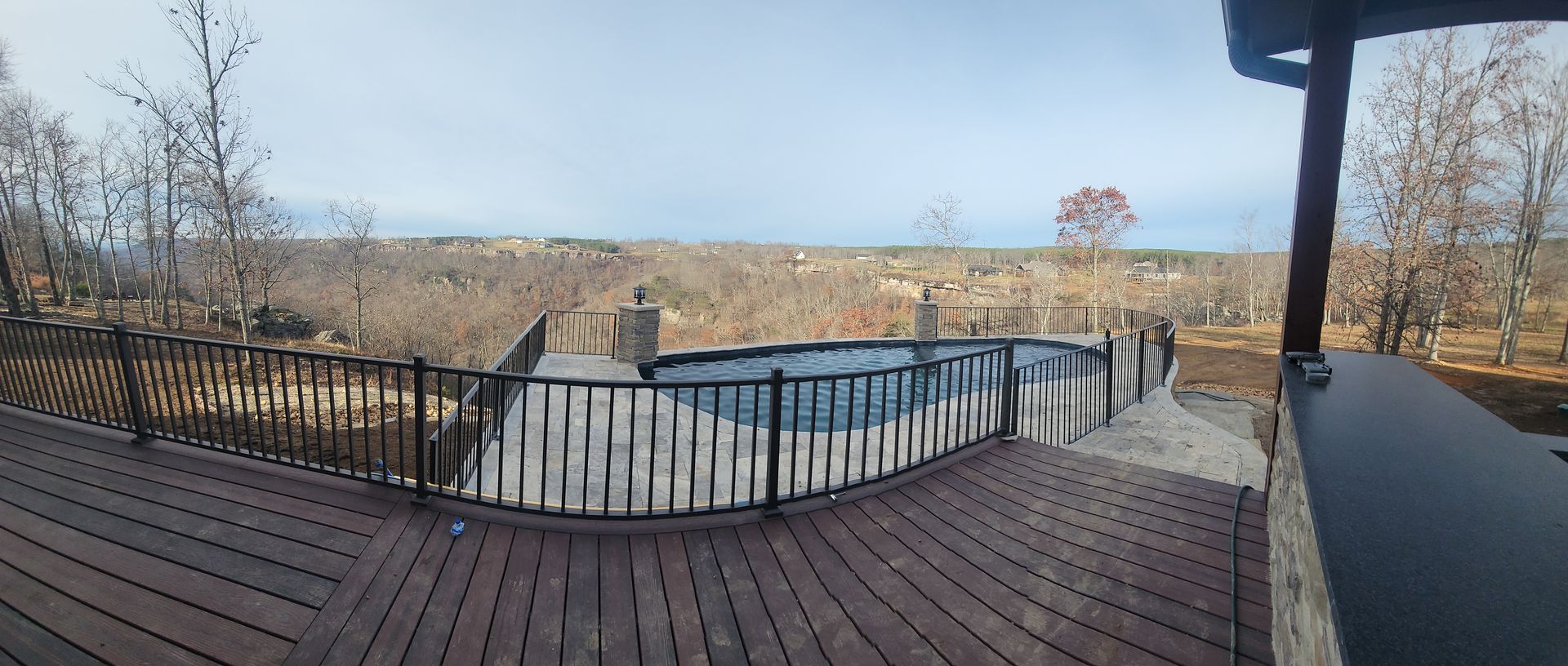 A large swimming pool is surrounded by a wooden deck.