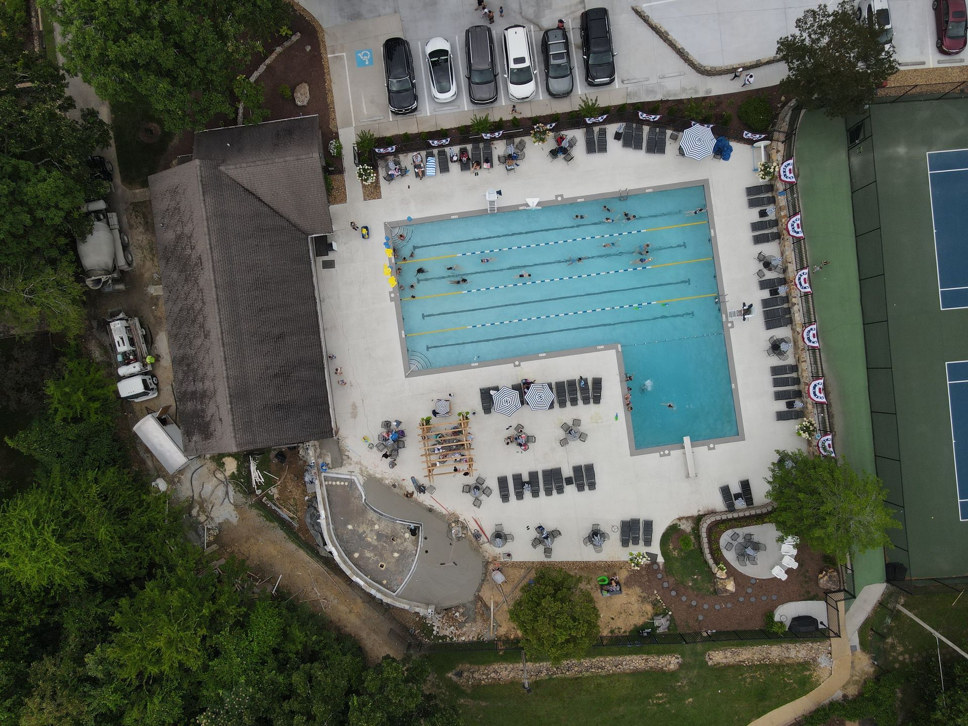 An aerial view of a swimming pool and tennis courts