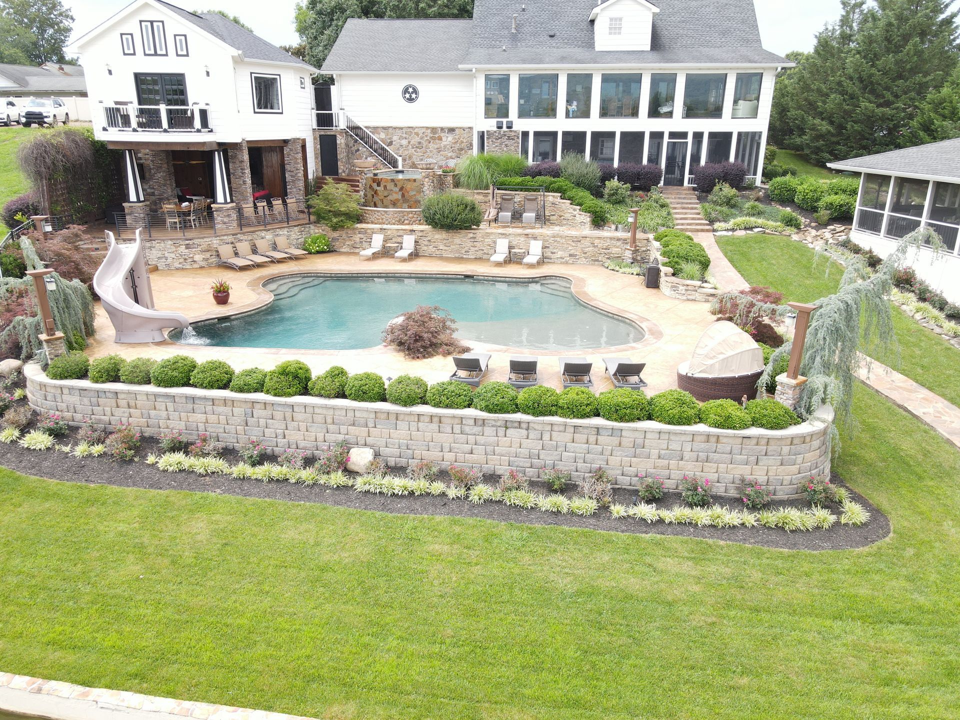 An aerial view of a large house with a swimming pool and a slide.