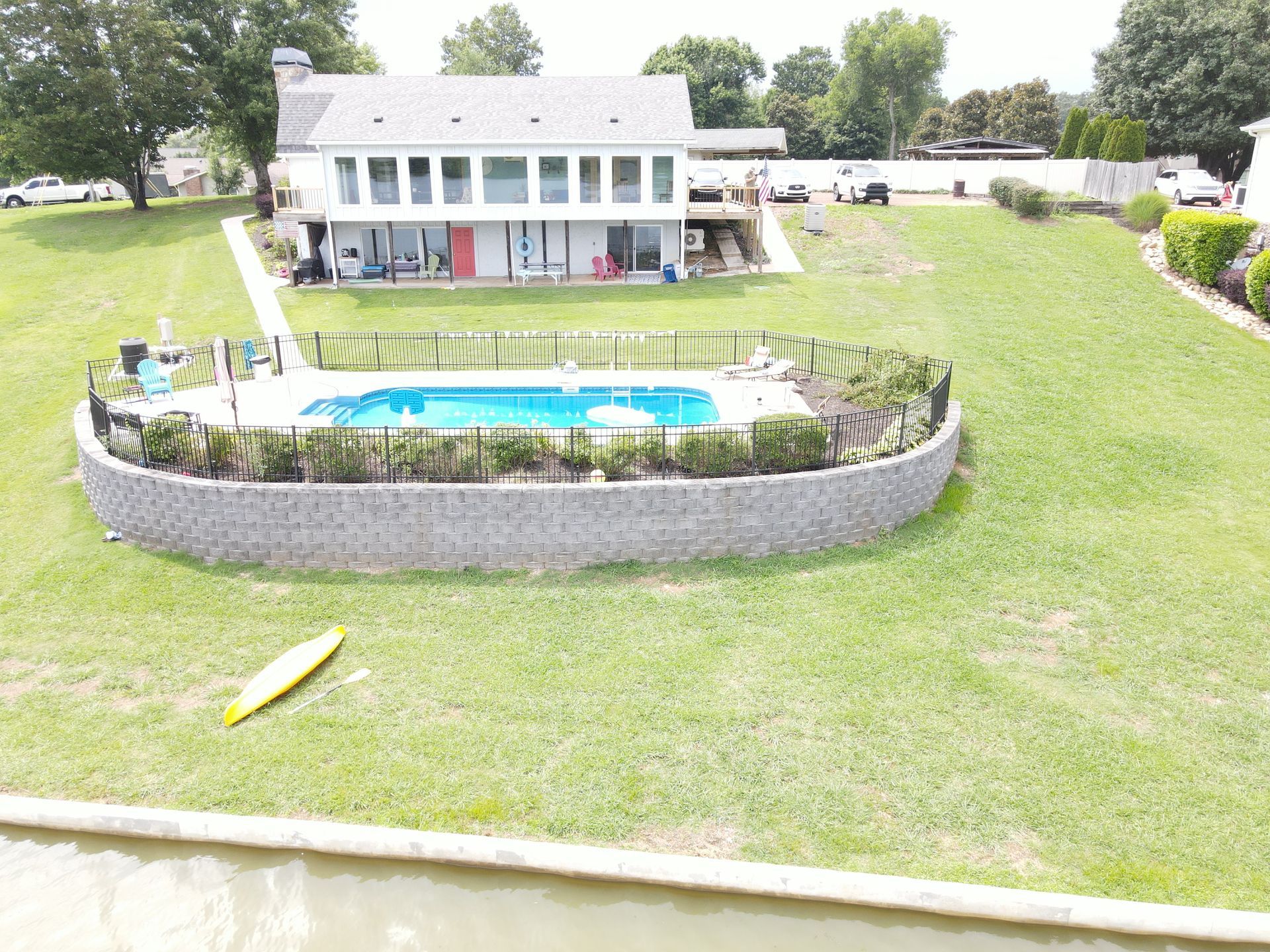 An aerial view of a house with a large pool