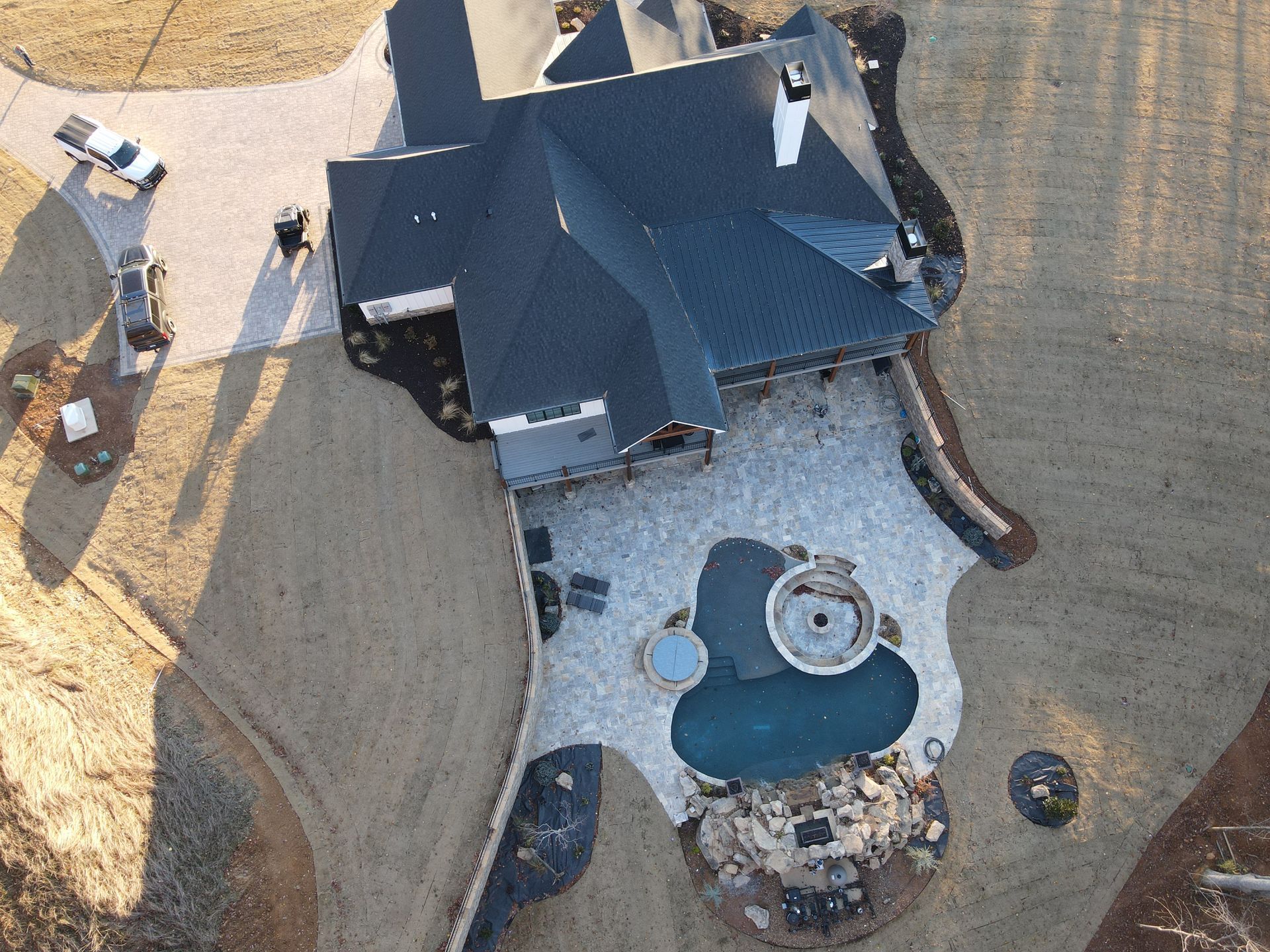 An aerial view of a house with a large pool