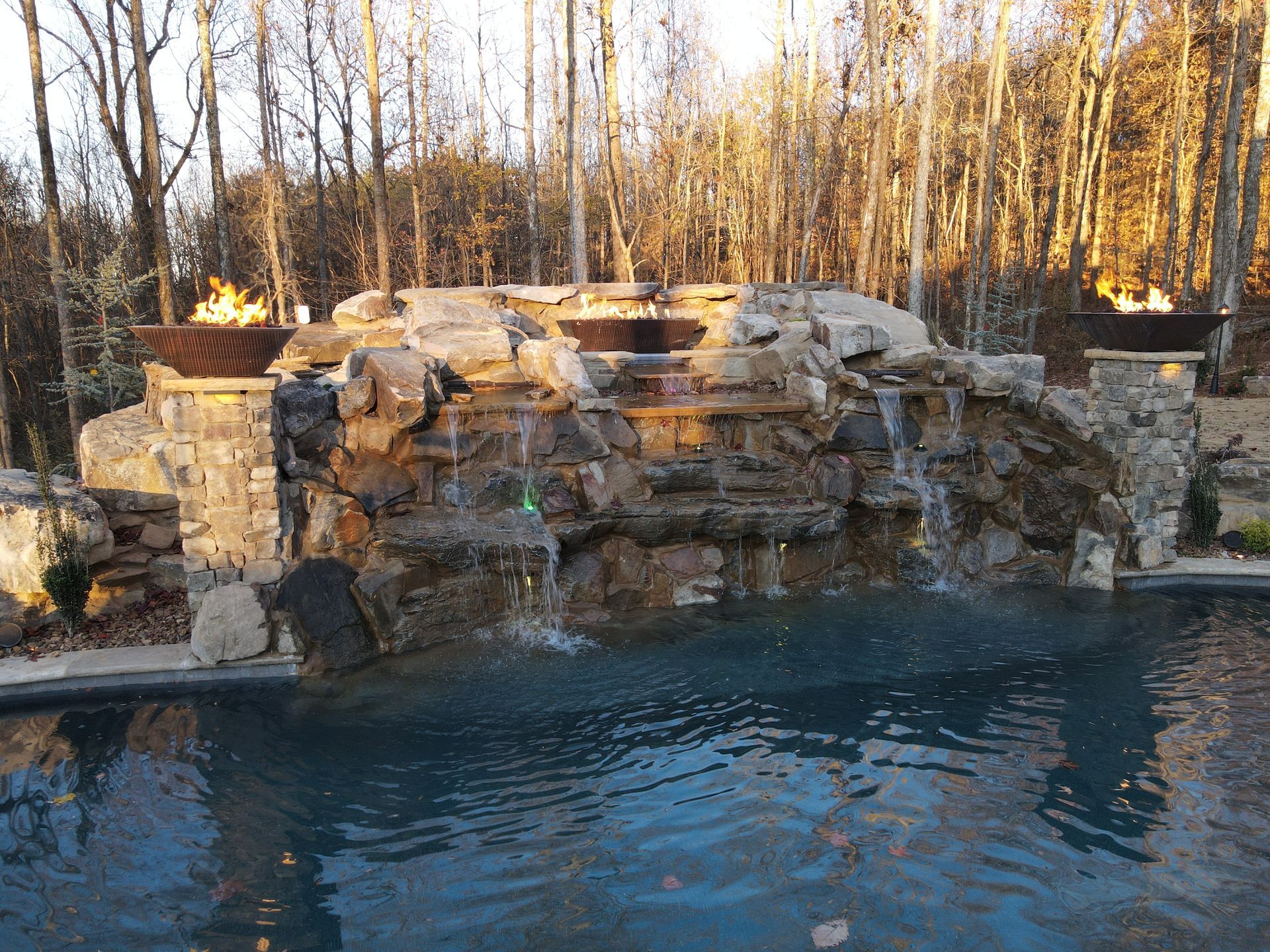 A large swimming pool with a waterfall in the background