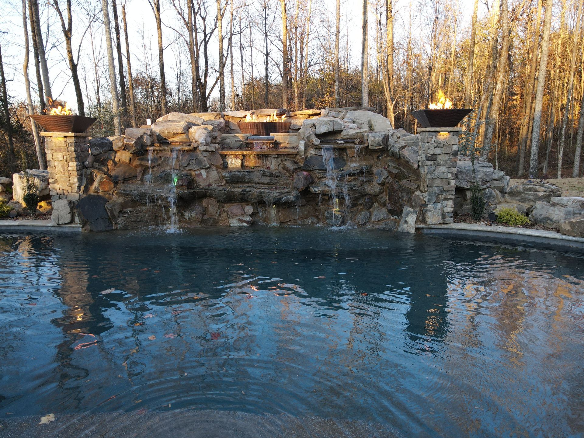 A large swimming pool with a waterfall in the background