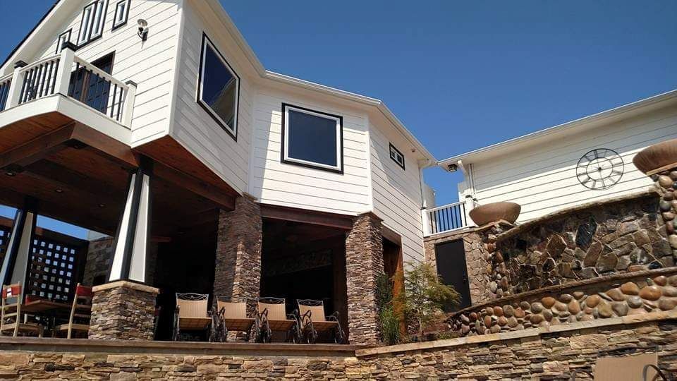 A large white house with a stone wall in front of it