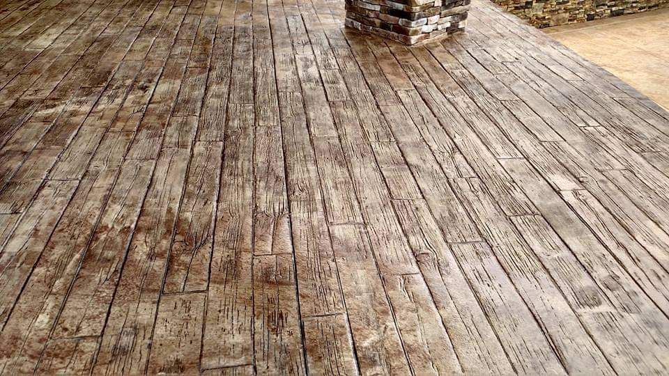 A close up of a wooden floor with a chimney in the background.