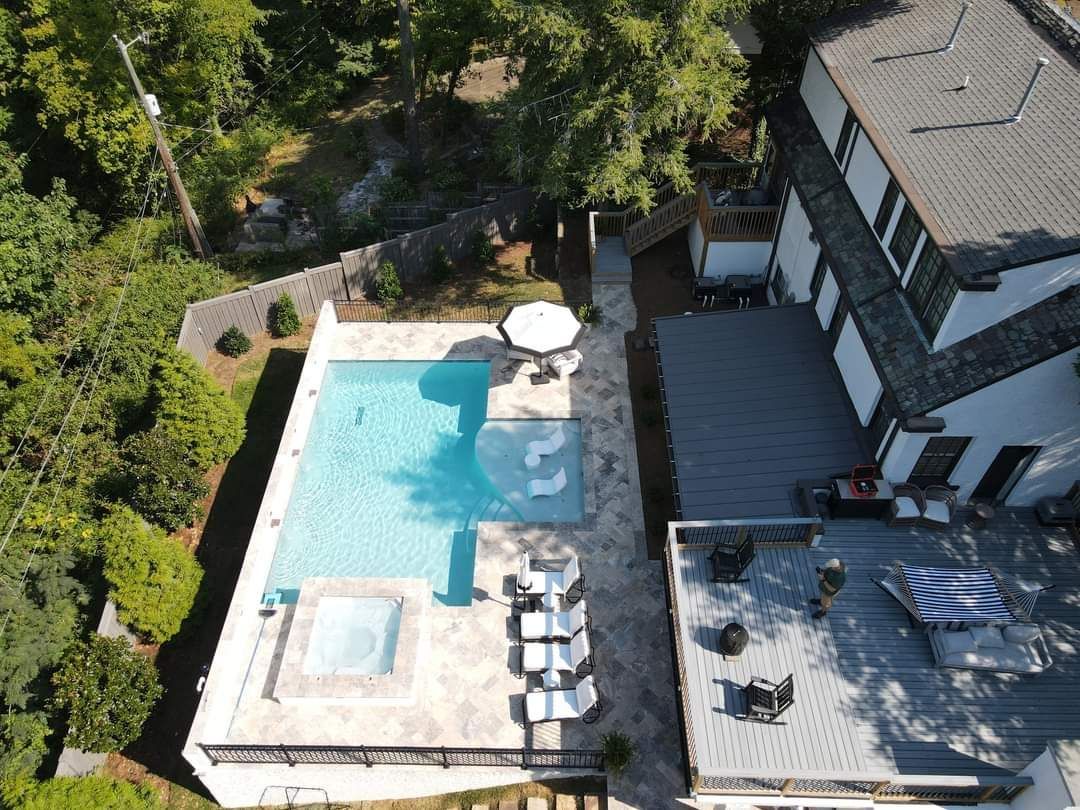An aerial view of a house with a large swimming pool