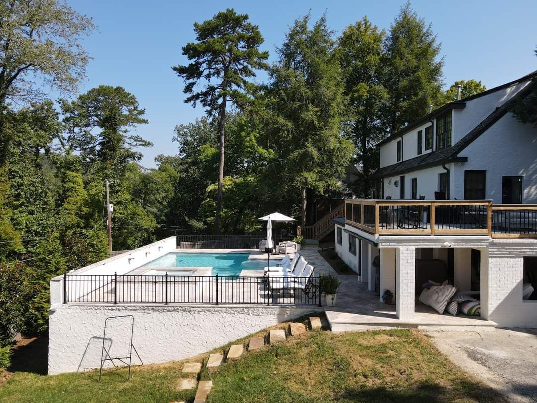 A large white house with a large swimming pool in the backyard