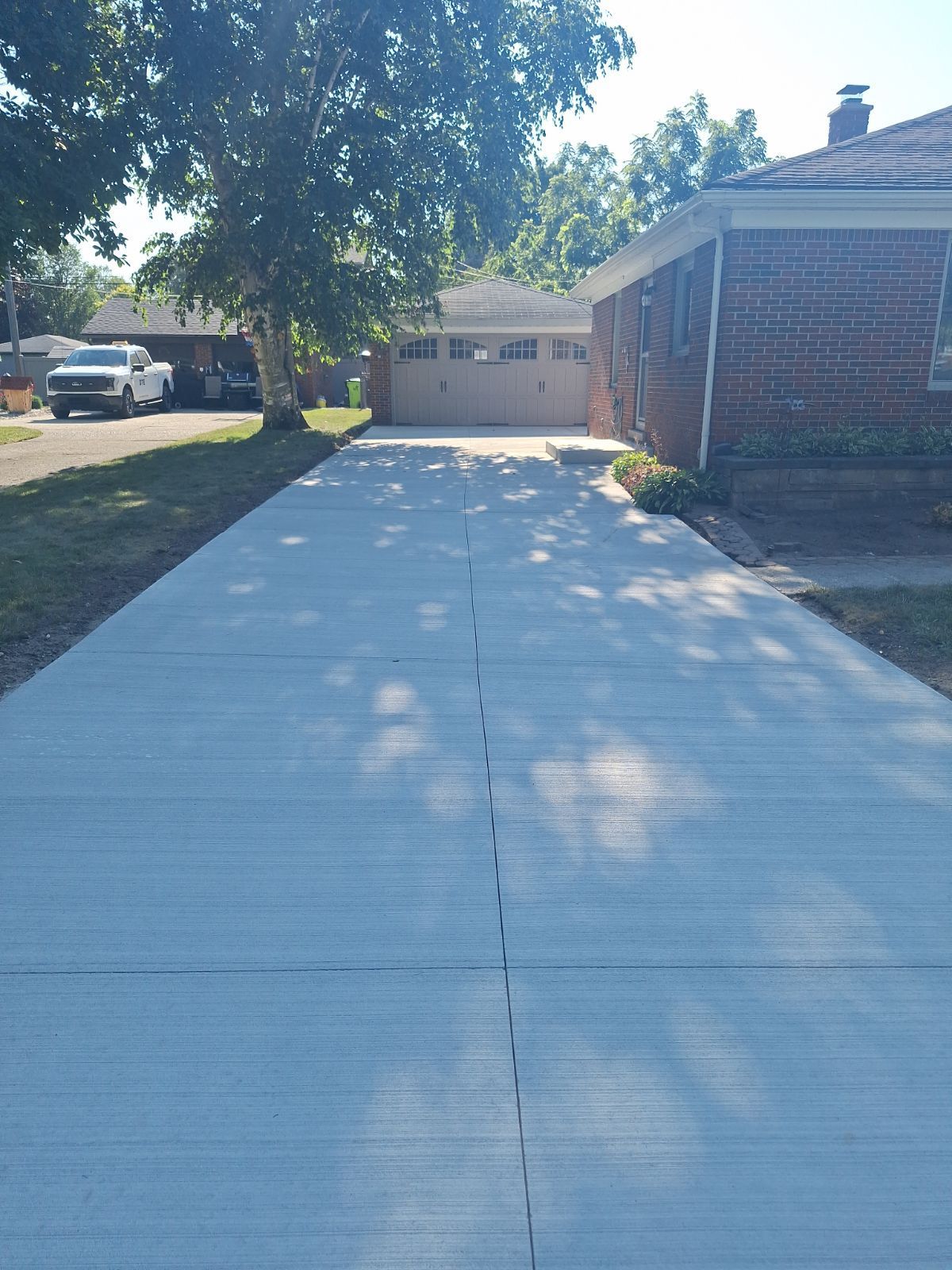 A concrete driveway leading to a brick house