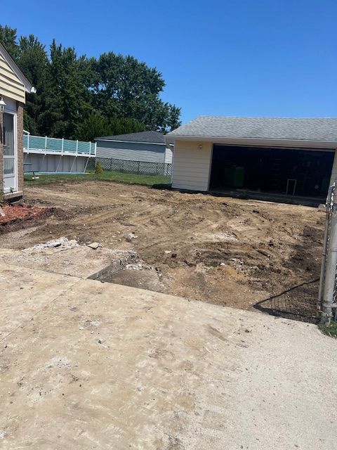 A house with a garage and a lot of dirt in front of it.