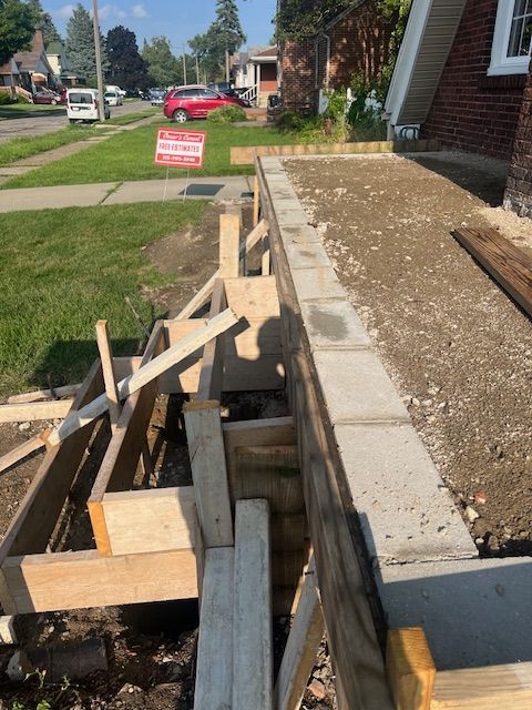 A brick wall is being built in front of a house.