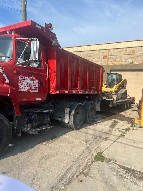 A red dump truck is parked in front of a building.