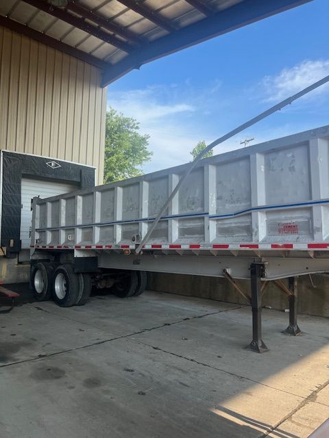 A dump truck is parked in front of a building.