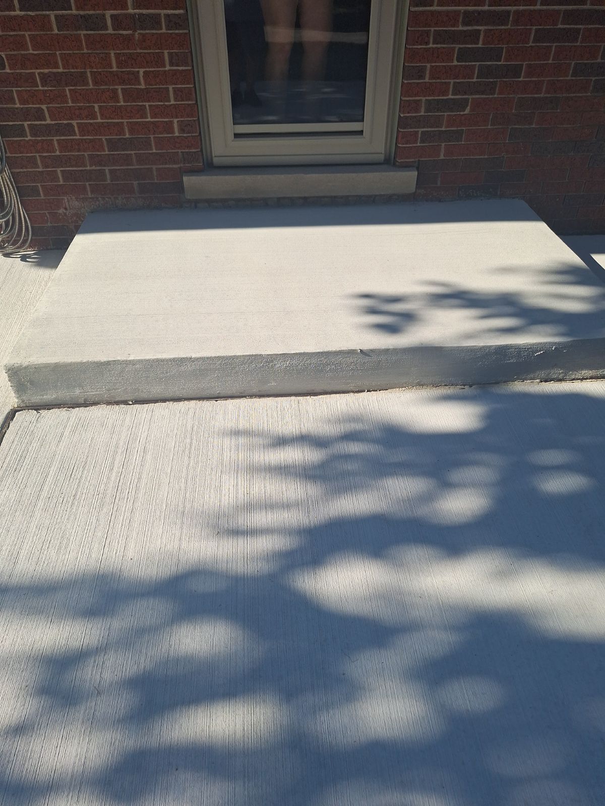 A brick building with a concrete step in front of it.