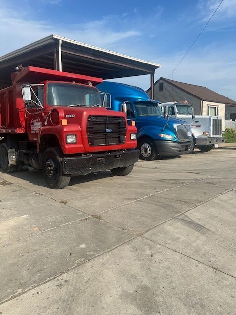 A row of trucks are parked in a parking lot