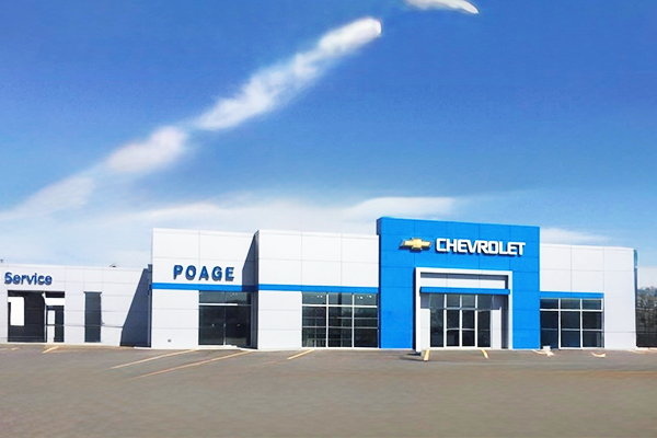 A white and blue chevrolet dealership with a blue sky in the background