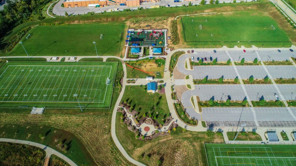 An aerial view of a soccer field and a parking lot.