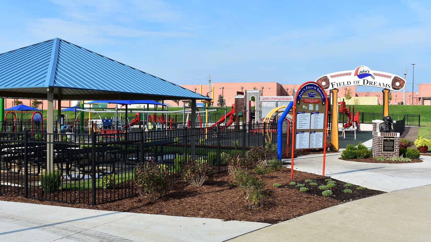 A park with a pavilion and a playground in the background.