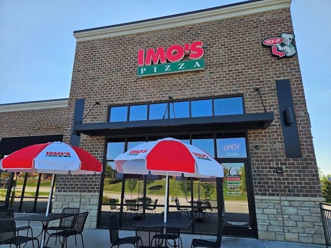 A brick building with a sign that says imo 's pizza