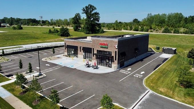 An aerial view of a building with a parking lot in front of it.