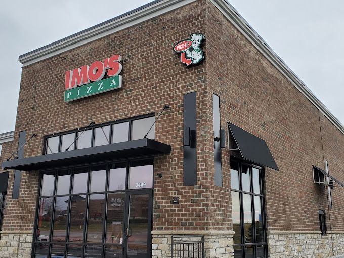 A brick building with a sign that says ' imo 's pizza ' on it