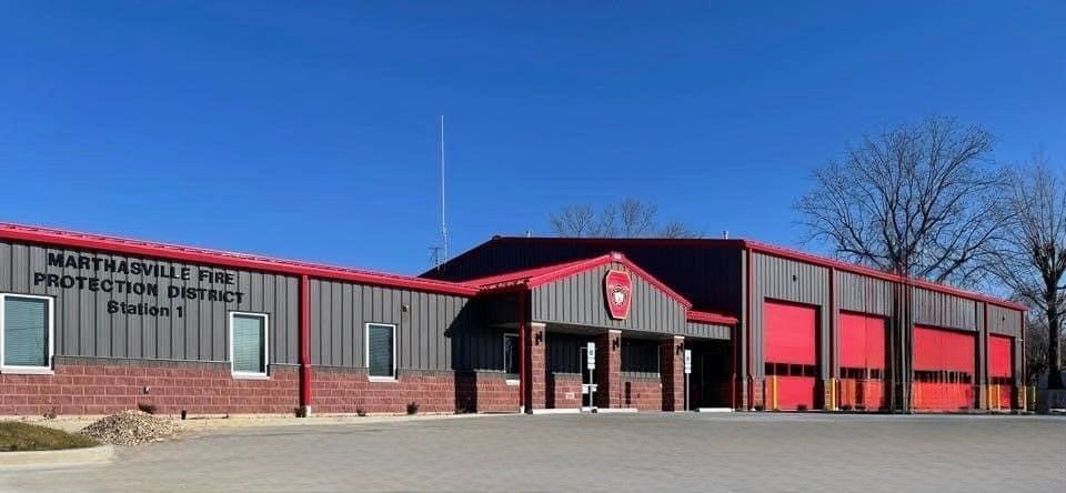 A large building with a red roof and red garage doors.