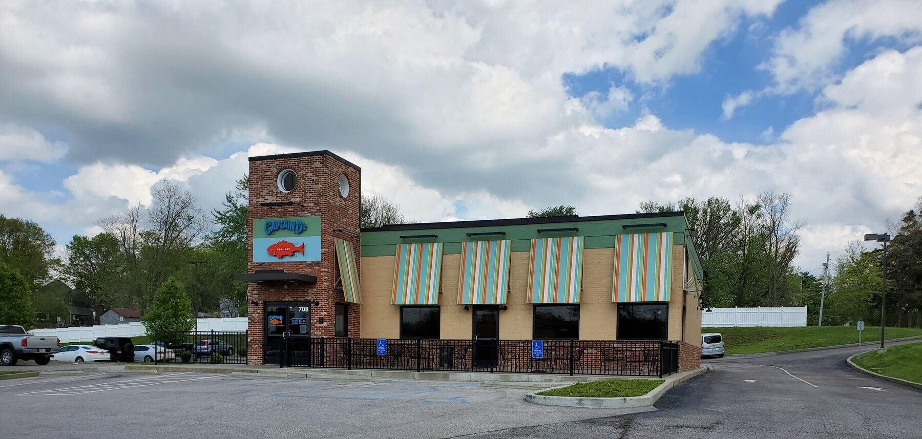 A car wash with a lot of cars parked in front of it on a cloudy day.