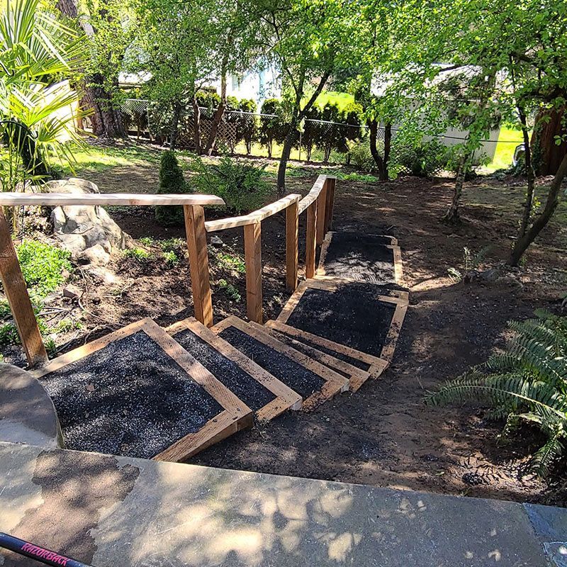 A wooden staircase is being built in a garden.