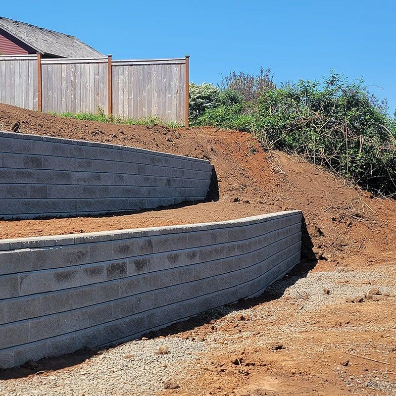A brick wall is being built on top of a dirt hill
