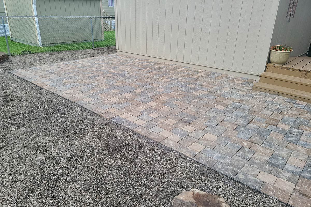 A brick walkway is being built in front of a house.