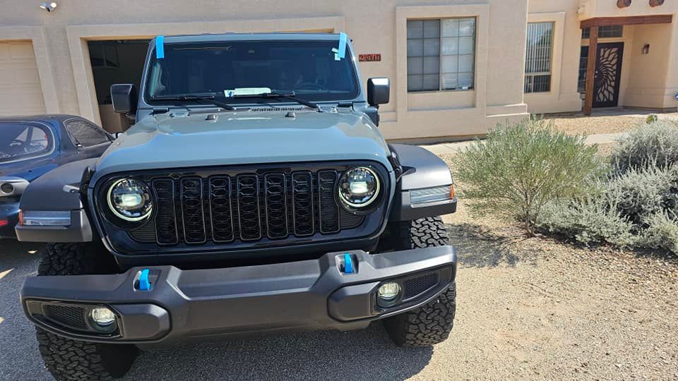 A jeep is parked in front of a house in a driveway.